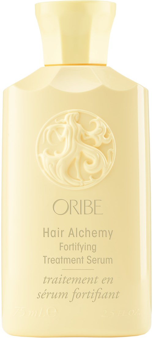 En kremhvitt flaske med en rund logo av en kvinne med flytende hår, merket "ORIBE Hair Alchemy Fortifying Treatment Serum."