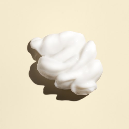 Ett vitt, fluffigt molnliknande objekt på en beige bakgrund.