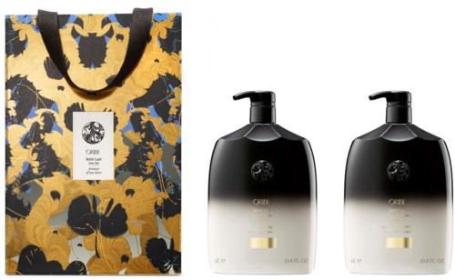 Two black and white bottles with pumps and a colorful gift bag with flowers and leaves.