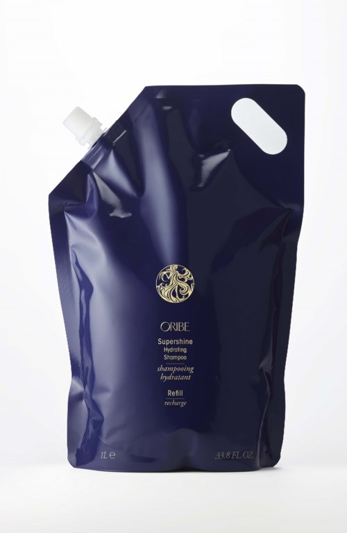 En mörkblå refillpåse för Oribe Supershine Hydrating Shampoo, med ett vitt lock och ett litet handtagshål.