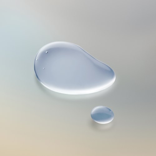 To vanndruper på en glatt overflate, en stor og en liten, reflekterer lys.