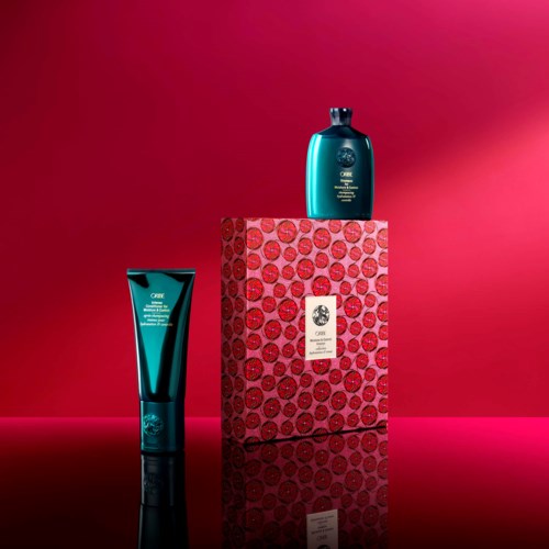Two blue skincare products are displayed on a pink and red patterned box against a pink background.