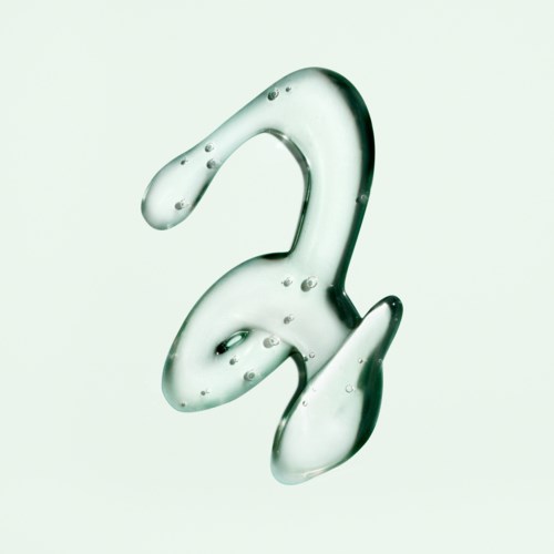 A clear, glass-like hook with water droplets on its surface, hanging against a light background.