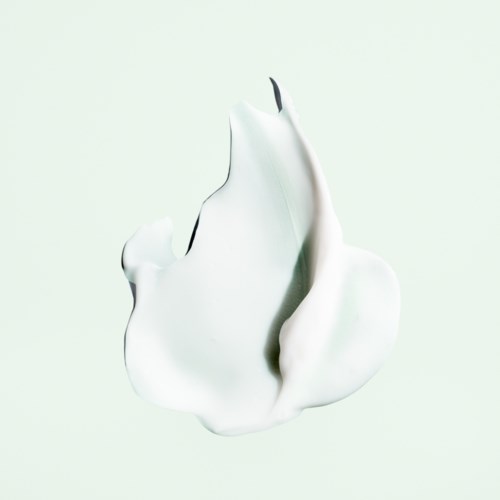 En hvit, glatt, abstrakt form med svart spiss, som ligner en moderne skulptur eller kunstverk.