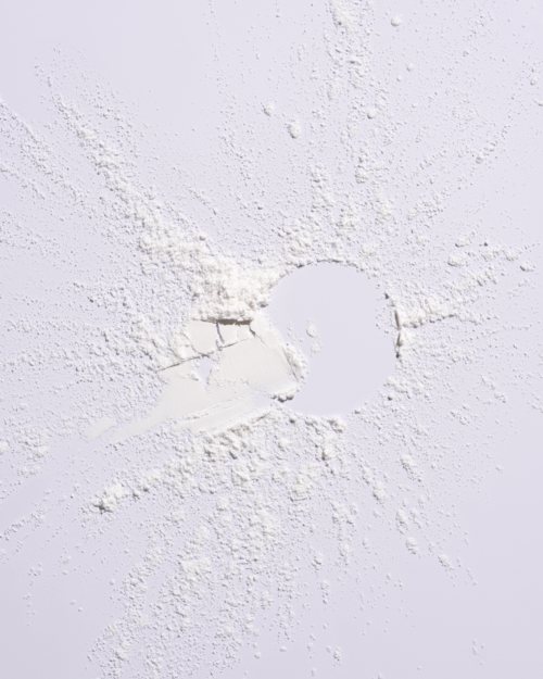A round object covered in a white powder with scattered powder around it.