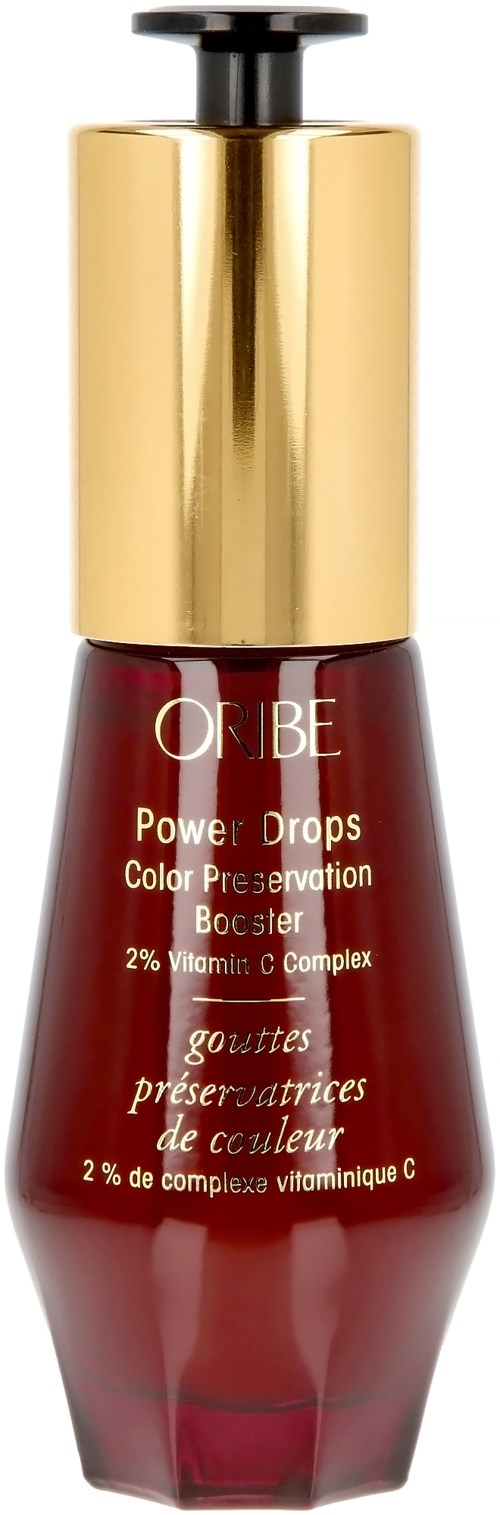 A red bottle with a gold cap, labeled "Oribe Power Drops" for skin. Contains vitamin C complex.