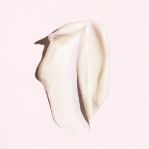 A creamy, soft substance with folds and a smooth texture, likely a dollop of whipped cream or lotion.