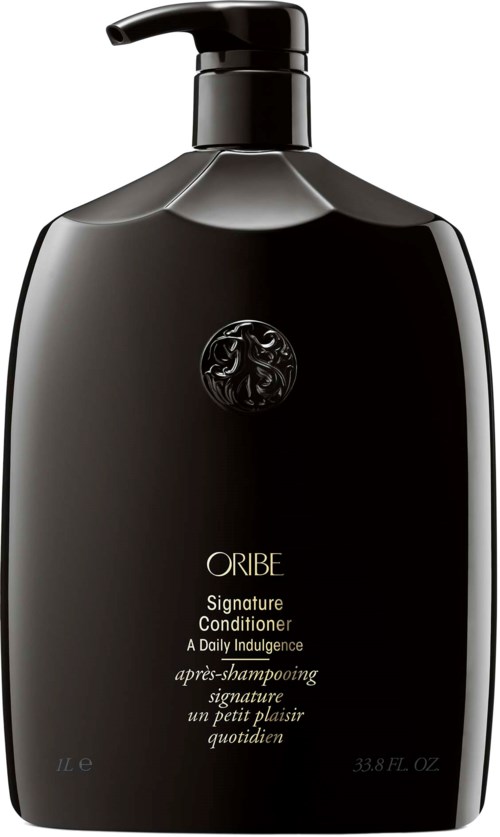 Svart flaska med pump, märkt Oribe Signature Conditioner, elegant design för hårvård.