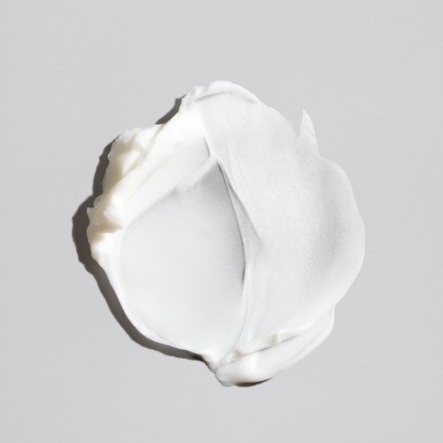 Een dot witte crème of lotion op een eenvoudige ondergrond. Glad textuur en zachte uitstraling.