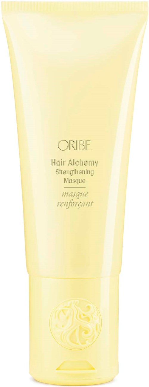 En gul tube av ORIBE Hair Alchemy Strengthening Masque med en lock längst ner.