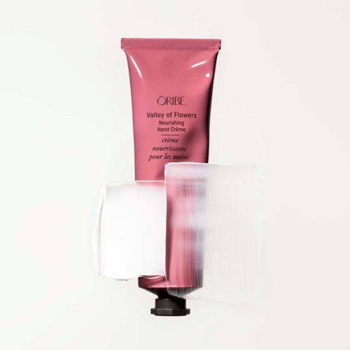 Pink tube of hand cream with clear plastic cover, labeled 'Valley of Flowers' by Oribe.