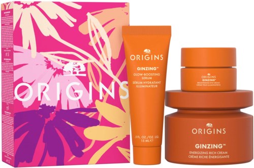 Ordrer i oransje flasker og en eske med rosa, lilla og gule blomsterdesign. Produktene er hudpleie- eller skjønnhetsprodukter.