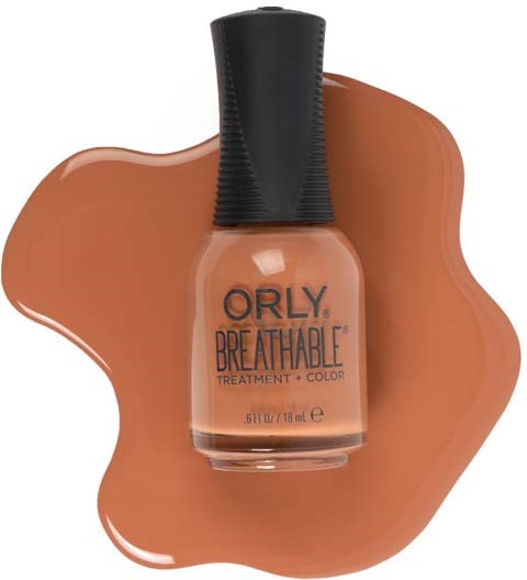 Flaske med neglelakk på en brun flekk, merket 'Orly Breathable Treatment + Color'.