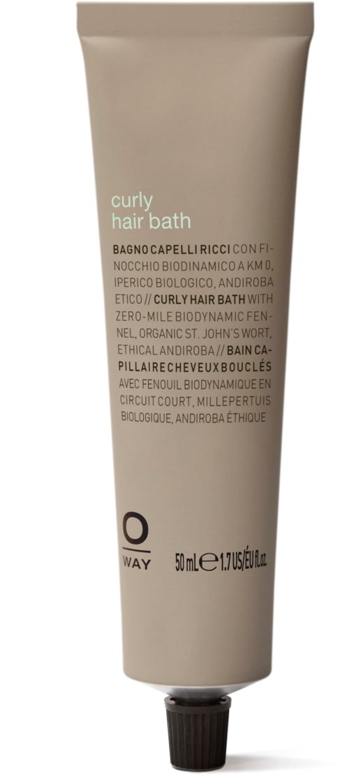 En beige tube med krøllete hårbad med svart lokk, inneholder 50 ml produkt, med tekst som beskriver ingredienser og bruk.