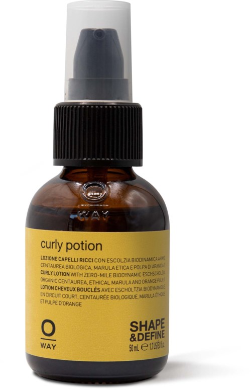 Liten brun flaske med gul etikett og svart pumpe, kalt 'curly potion' for hårstyling.