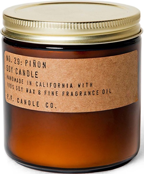 Een bruin glazen pot met een gouden deksel, gemerkt als sojawas- en geurolie-kaars uit Californië.