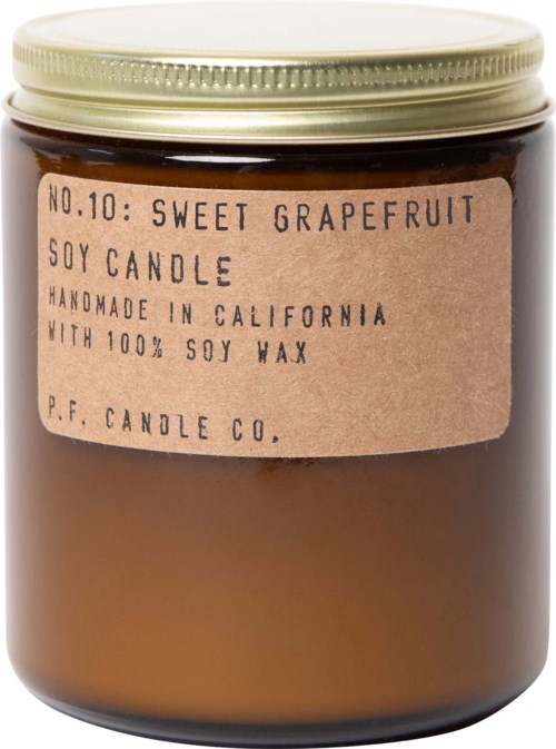 Een bruine kaars in een glazen pot met een beige deksel en een label met "Sweet Grapefruit" sojakaars, handgemaakt in Californië.
