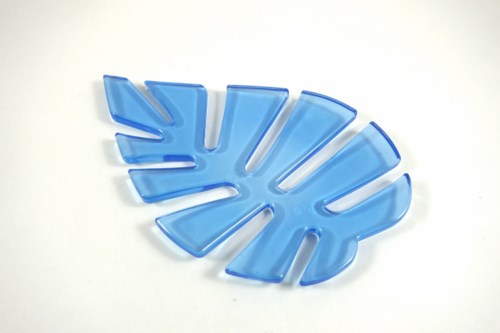 En blå plastbladformet tallerken med utskjæringer, plassert på en hvit overflate.