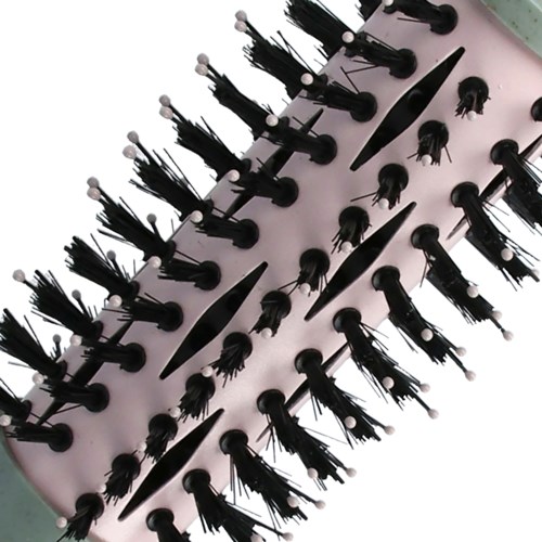 A black hairbrush with wide bristles and sections, a comb, and a small hair clip on a pink surface.