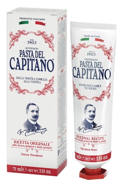 En tub och förpackning av tandkräm med ett vintage-aktigt logotyp, ett fotografi av en man och italiensk text om originalitet och familj.