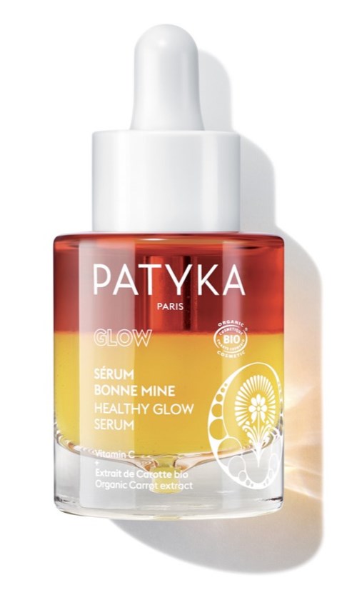 En liten, genomskinlig flaska med orange- och gulmärkning och en vit pipettlock, märkt Patyka Paris.