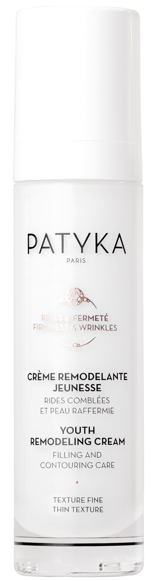 En vit flaska med Patyka-kräm för ungdomsuppbyggnad, med svart text och en liten logo.