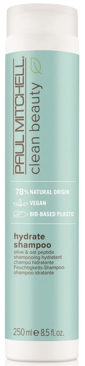 En lang, hvit flaske med en lyseblå etikett, inneholder hydratiserende sjampo fra Real Techniques, vegansk og laget av naturlige ingredienser.