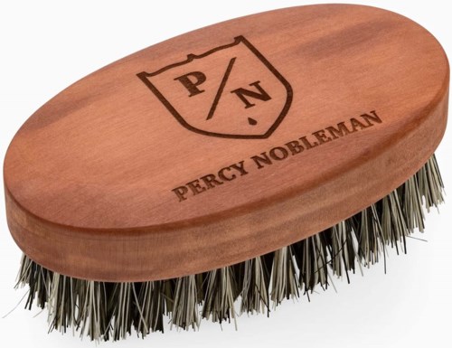 Eine Holzbürste mit Metallborsten und einem Logo mit "Percy Nobleman" und "P/N" auf der Oberseite.