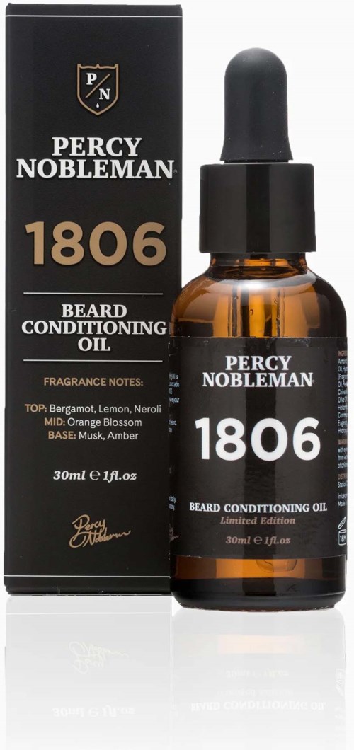Kleine bernsteinfarbene Flasche mit Tropfer, beschriftet Percy Nobleman Bartöl, neben der Verpackung. Es ist ein Pflegeprodukt.