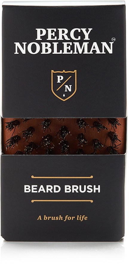 Svart förpackning med vit och guld text, visar en skäggborste inuti genomskinlig del, märkt Percy Nobleman.