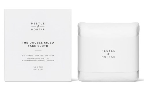 Det visar en box med dubbelsidiga ansiktshanddukar och dess förpackning, allt i vitt, med svart text som nämner PESTLE MORTAR.