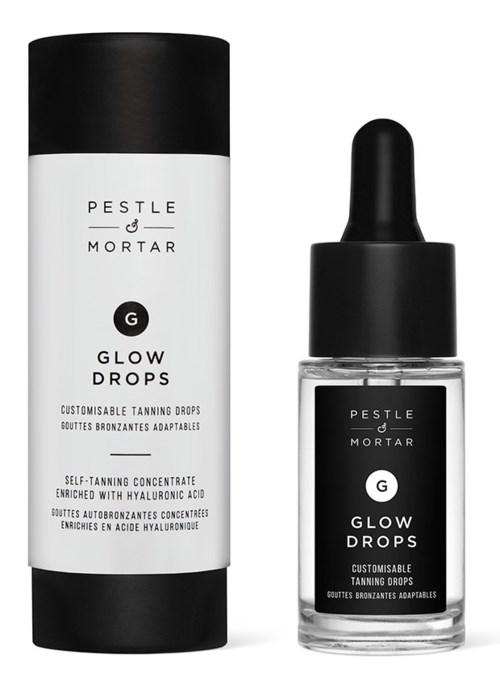 Czarna i biała butelka z opakowaniem PESTLE & MORTAR Glow Drops, produktem do samoopalania z kwasem hialuronowym.