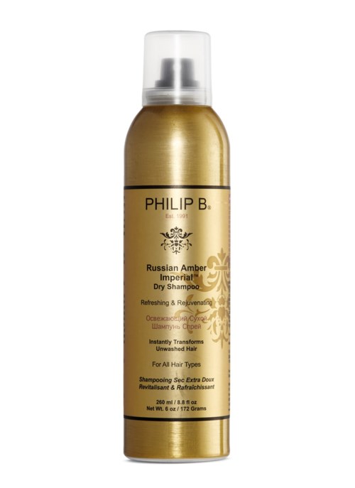 En gullfarget flaske med Philip B Russian Amber Imperial tør shampoo med klar kork.