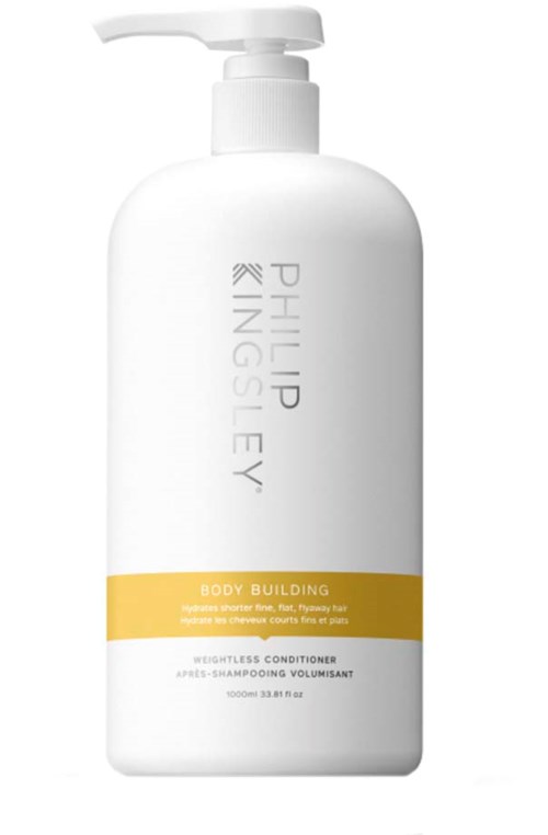En hvit flaske med pumpe, merket "Philip Kingsley" og "Body Building" i gult, for hårbalsam.