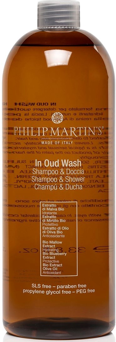 En brun plastflaske med hvit lokk inneholder Philip Martin's Oud Wash sjampo. Labelen er oransje med tekst.