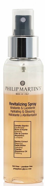 Przezroczysta butelka z rozpylaczem oznaczona 'Revitalizing Spray' z czarnym dyskiem i srebrną obręczą, zawierająca produkt do skóry.