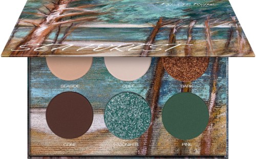 A makeup palette with six colorful eyeshadows in a book-like case with a nature scene on the cover.
