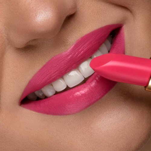 Närbild på en person med rosa läppstift och vita tänder, som håller ett matchande rosa läppstift mot läpparna.