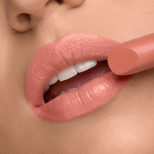 Close-up of lips holding a pink lipstick, showing smooth skin and white teeth.