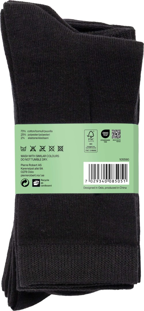 A pair of black socks with a green tag wrapped around. The tag has text and symbols for laundry instructions.