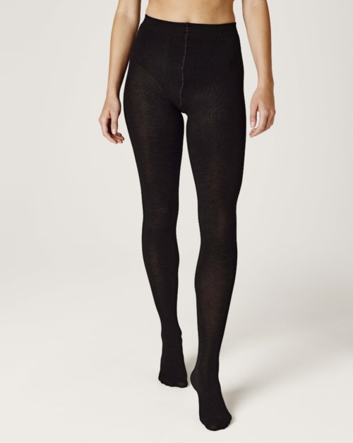 A woman wears tight black leggings that cover her legs completely.