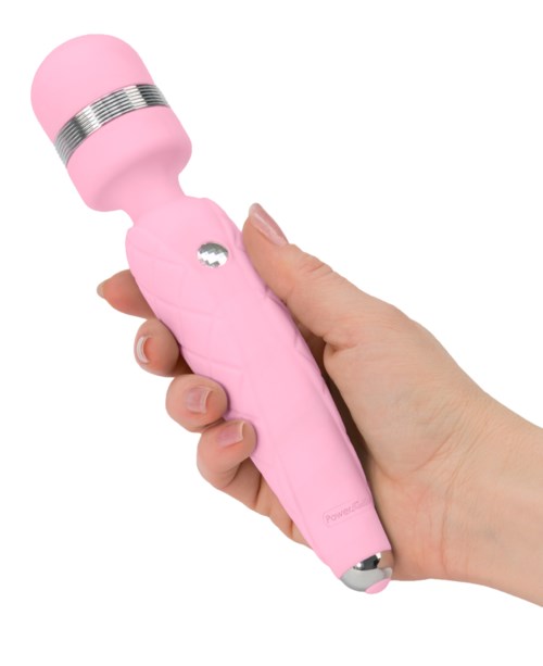A pink handheld device with a rounded top, held in a person's hand, possibly used for massage or skincare.