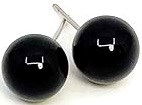 Black spherical balls with white numbers, connected by a metal chain, used in a balance scale.
