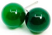 Two green billiard balls are close together on a white surface.