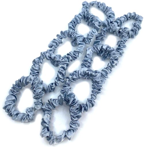 Six blue fabric hairbands with ruffled edges are intertwined together on a white background.