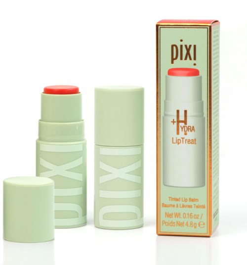 En läppbalsamprodukt med varumärket Pixi, i ett vitt paket med orange detaljer och ett rött lock.