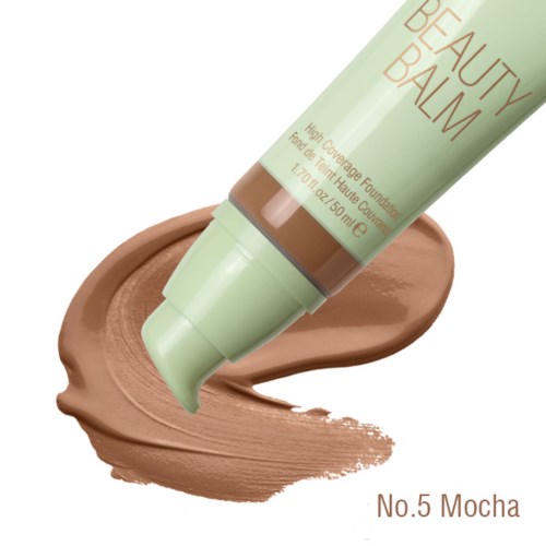 Eine Tube mit High-Coverage-Grundierung mit der Aufschrift 'Beauty Balm' wird auf eine beige Oberfläche gedrückt. Das Produkt heißt No. 5 Mocha.