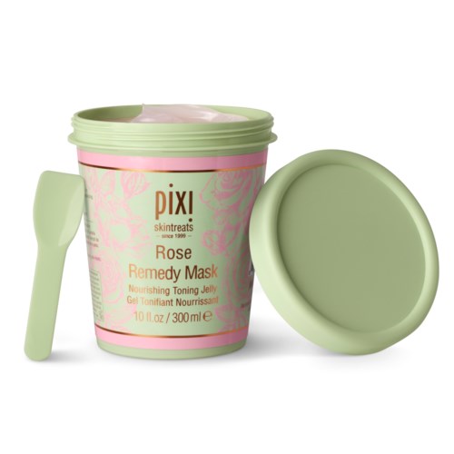 En rosa og grønn beholder merket som rose remedy mask, med en spatula ved siden av, brukt til hudpleie.