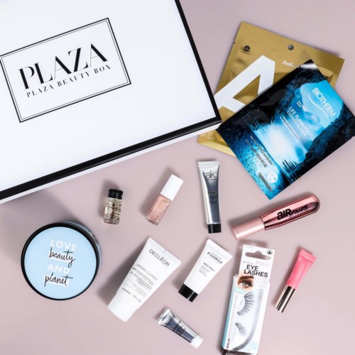 En skönhetslåda med hudvård, makeup och skönhetsprodukter på en rosa bakgrund.