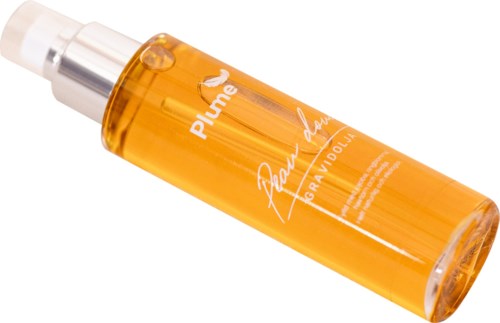 Żółto-pomarańczowa butelka spray z napisem 'Plume' i białym tekstem, położona pod kątem.